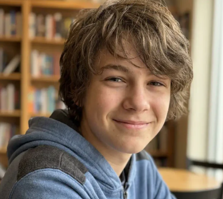 A smiling teenage boy in a school library